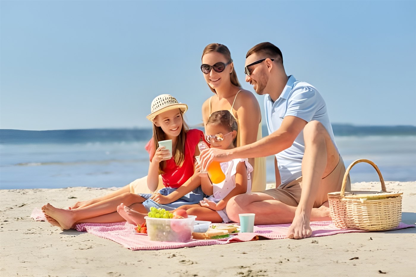 Family on the beach as on vacation or holiday stock image used in a blog post listing 10 tips to help plan a family vacation