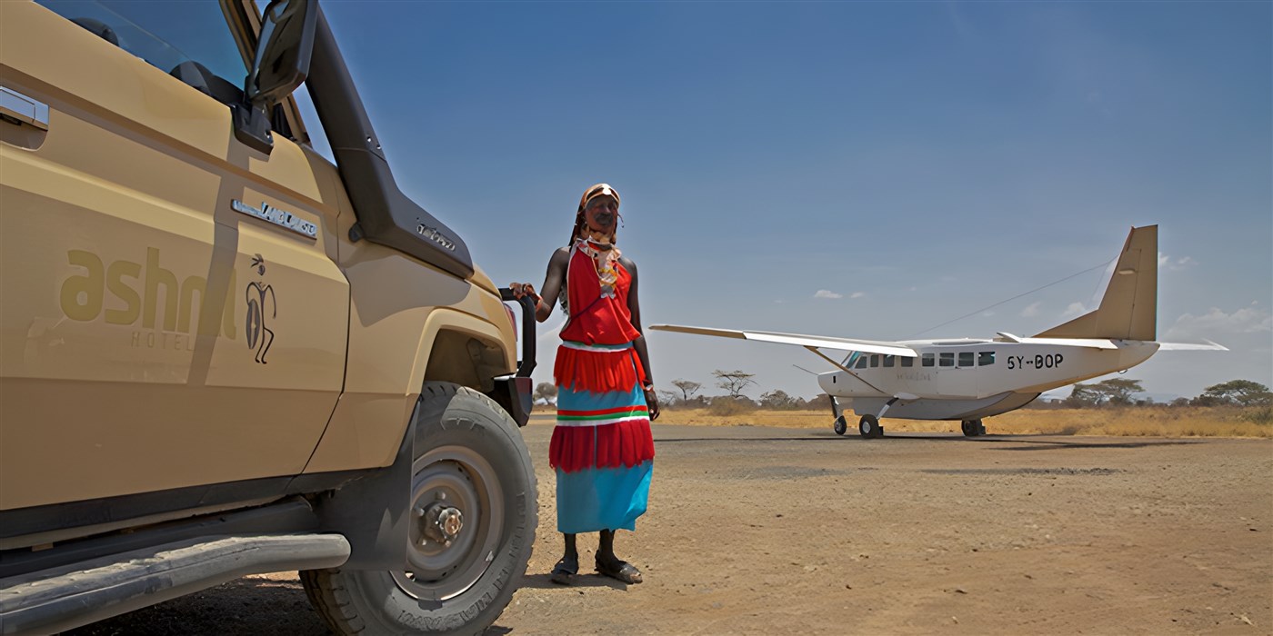 Masai warrior beside a Somak safari vehicle