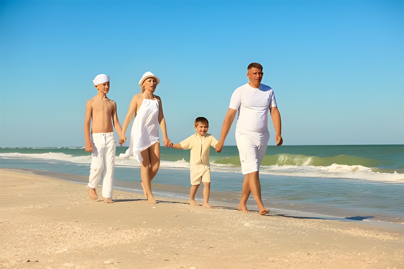 A family of four walking on the beach added to a blog post about family travel including safari and beach holidays