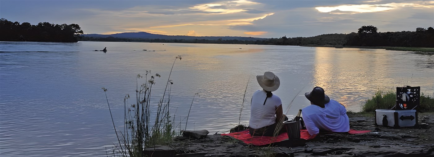 Couple overlooking the water in Selous, Tanzania, Africa