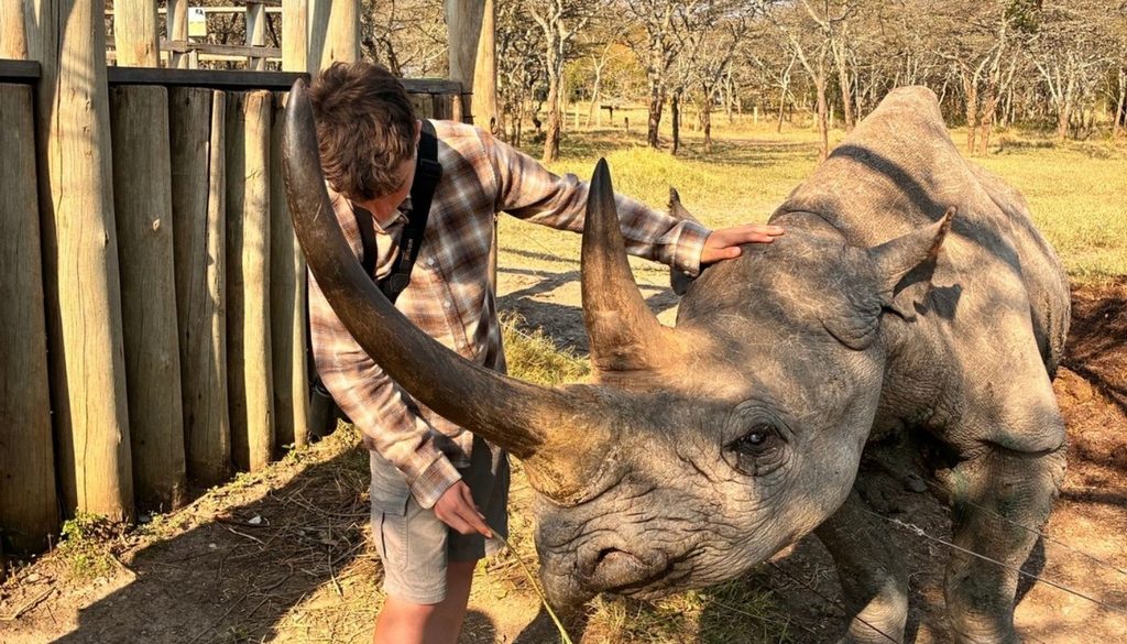Liz's teenaged son feeding Baraka the blind rhino at Ol Pejeta Conservancy during a family safari in Kenya with Somak Luxury Travel in August of 2026