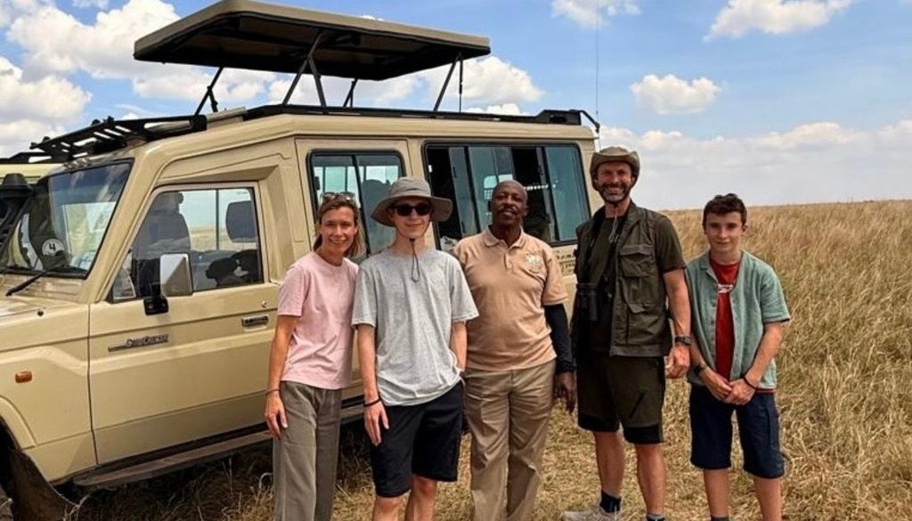 Liz and her family with Somak Driver Guide, Patrick outside his safari 4x4 vehicle while on a family safari in Kenya in August 2026